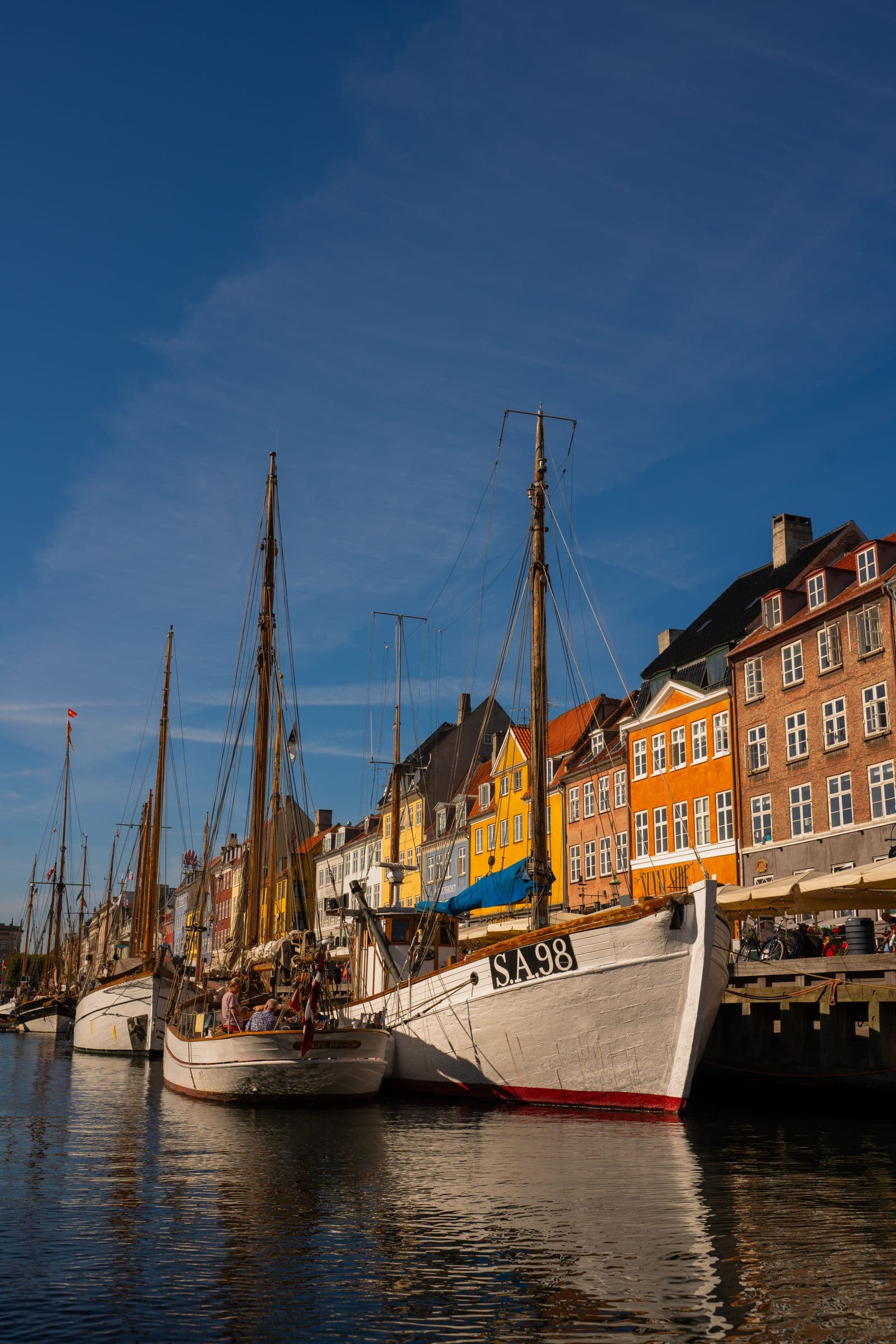Fargerike bygninger og båter langs havnen