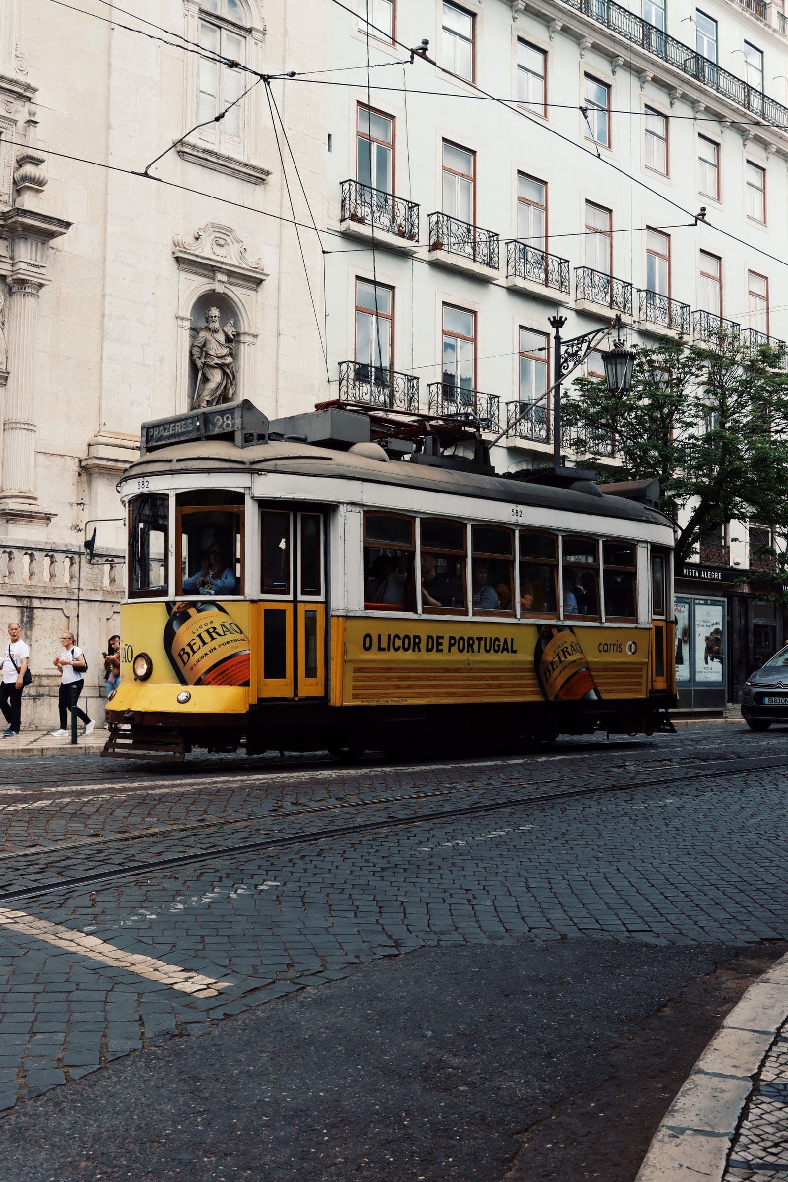 En gul trikk i en gate i Lisboa